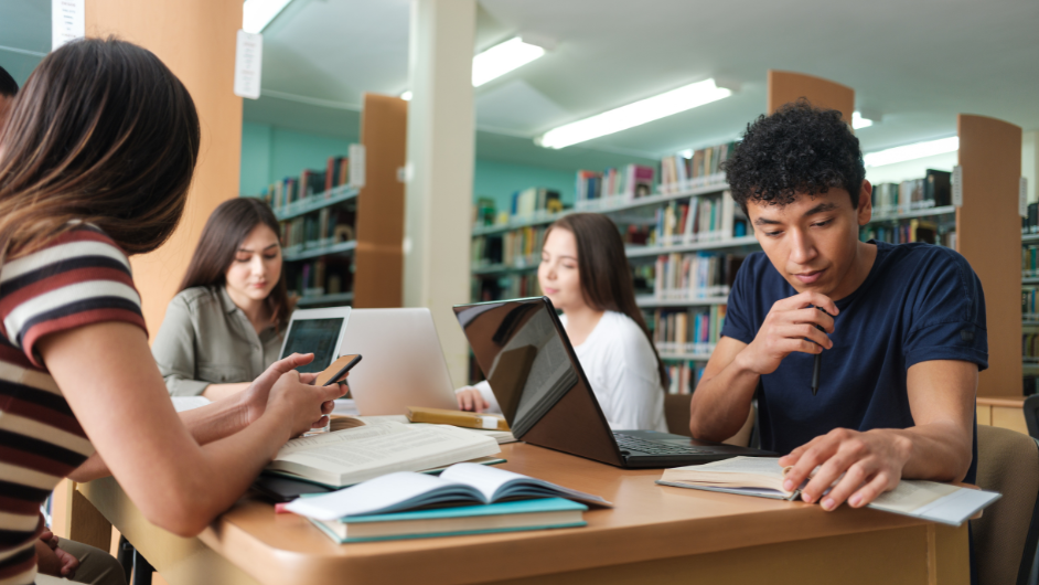 a imagem mostra um grupo de pessoas estudando em uma faculdade